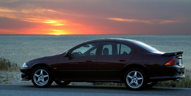photograph of a holiday rental car by a beach